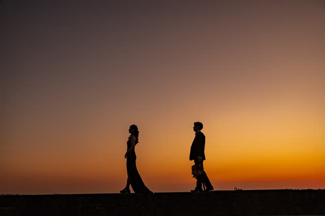 夕陽の中を歩くふたりのシルエット
